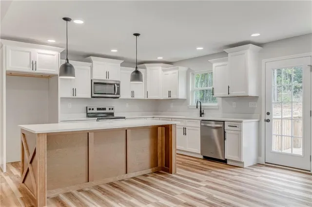 a kitchen with stainless steel appliances granite countertop a sink and cabinets