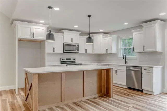 a kitchen with white cabinets and white appliances
