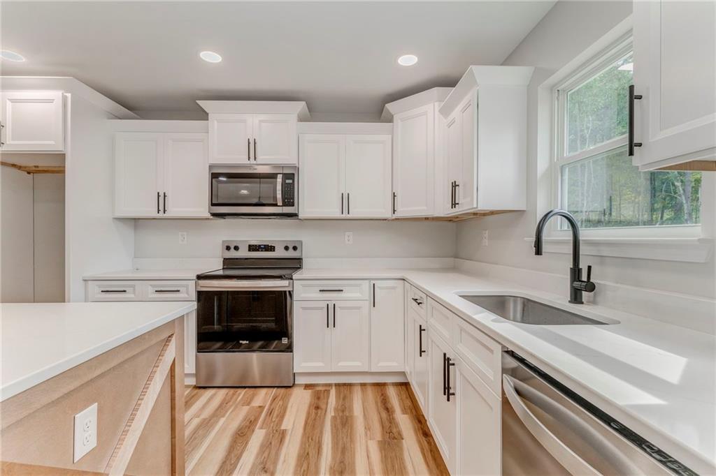 22 Earls Way Chatsworth, GA 30705 - Photo 36 of 64 a kitchen with stainless steel appliances granite countertop a sink and stove top oven