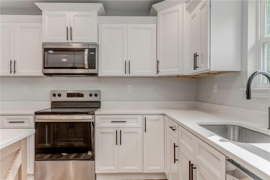 22 Earls Way Chatsworth, GA 30705 - Photo 37 of 64 a kitchen with white cabinets and stainless steel appliances