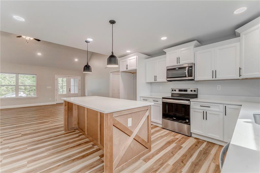 22 Earls Way Chatsworth, GA 30705 - Photo 38 of 64 a kitchen with kitchen island white cabinets appliances and sink