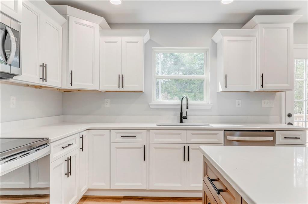 22 Earls Way Chatsworth, GA 30705 - Photo 41 of 64 a kitchen with white cabinets and white appliances