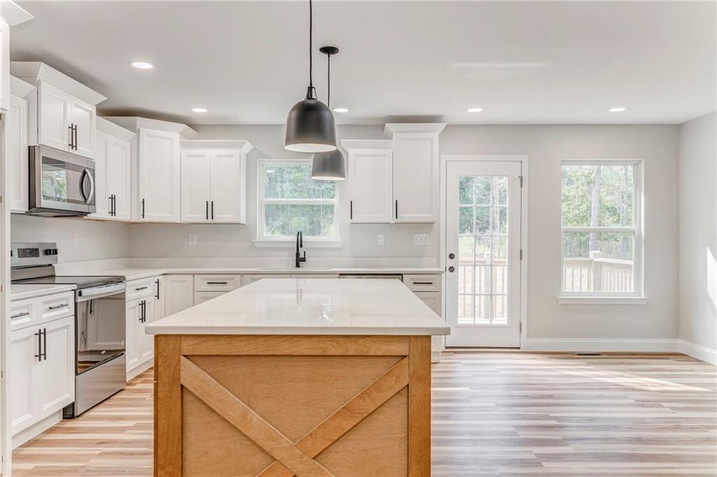 22 Earls Way Chatsworth, GA 30705 - Photo 44 of 64 a kitchen with stainless steel appliances kitchen island granite countertop a sink a stove and a wooden floors