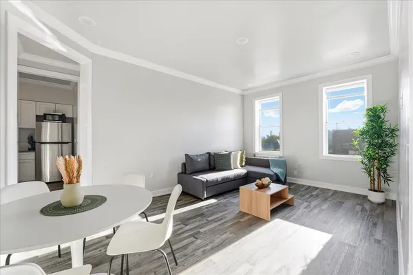 a living room with furniture a window and wooden floor