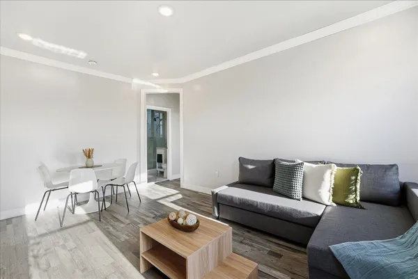 a very nice looking room with wooden floor and furniture