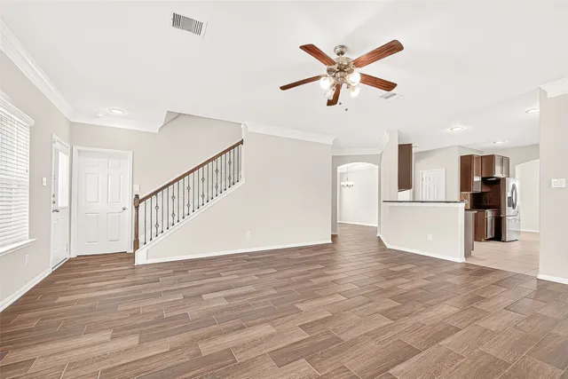 a view of a livingroom with a ceiling fan and wooden floor