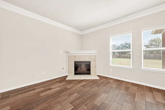 wooden floor fireplace and windows in an empty room