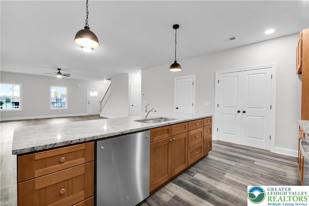 6 West 1st Street Northampton, PA 18067 - Photo 10 of 45 a kitchen with stainless steel appliances granite countertop white cabinets and a wooden floor