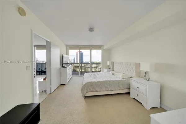 a room with a bed and a view of living room