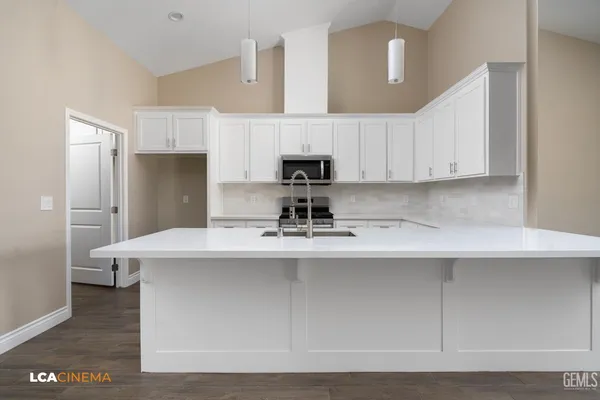a kitchen with stainless steel appliances a sink a stove a refrigerator and cabinets