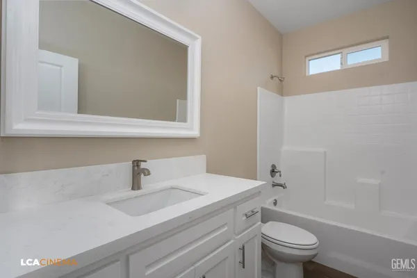 a bathroom with a sink toilet a mirror and shower