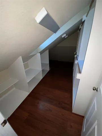 a view of a livingroom with wooden floor and a fireplace