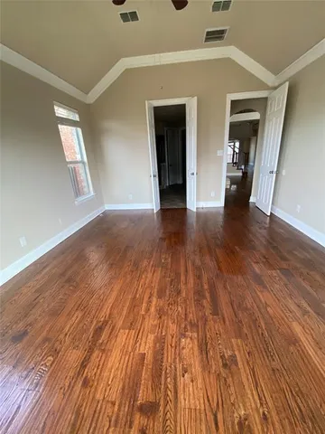 a view of empty room with wooden floor