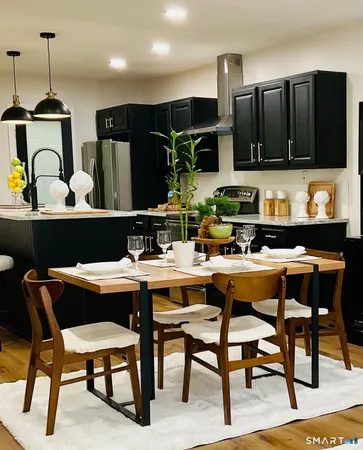 a kitchen with stainless steel appliances kitchen island granite countertop a dining table and chairs