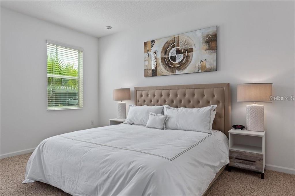 2626 Calistoga Avenue Kissimmee, FL 34741 - Photo 24 of 43 a bedroom with a bed and painting on the wall