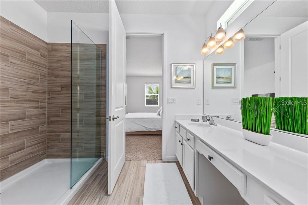 2626 Calistoga Avenue Kissimmee, FL 34741 - Photo 25 of 43 a bathroom with a double vanity sink and mirror with bathtub
