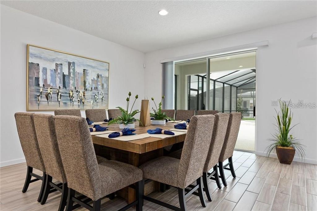 2626 Calistoga Avenue Kissimmee, FL 34741 - Photo 9 of 43 a dining room with furniture potted plants and wooden floor