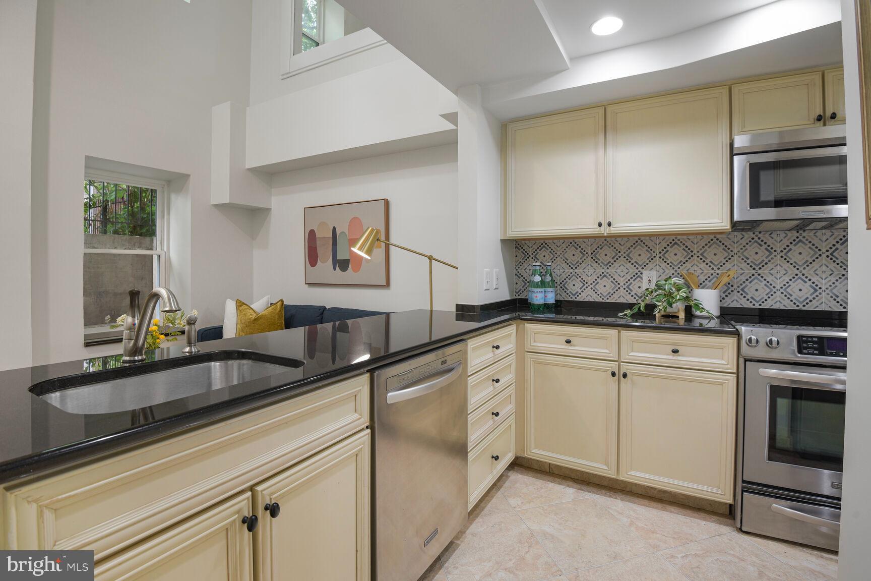 1437 Rhode Island Avenue Northwest, Unit 101 Washington, DC 20005 - Photo 20 of 36 a kitchen with stainless steel appliances granite countertop a sink stove and microwave
