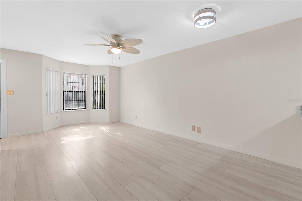 2302 South Maki Road, Unit 66 Plant City, FL 33563 - Photo 11 of 35 an empty room with wooden floor ceiling fan and windows