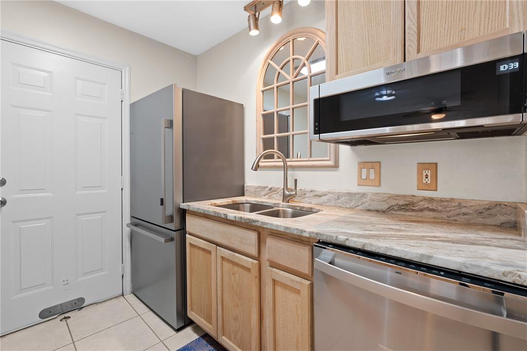 2302 South Maki Road, Unit 66 Plant City, FL 33563 - Photo 17 of 35 a kitchen with stainless steel appliances granite countertop a sink and a stove top oven with wooden floor