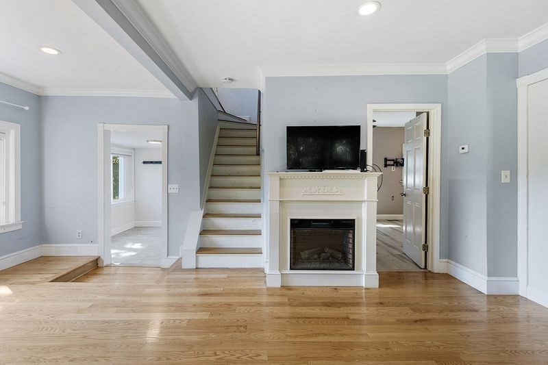150 Windsor Avenue Swampscott, MA 01907 - Photo 5 of 39 a view of a livingroom with a fireplace a ceiling fan and windows