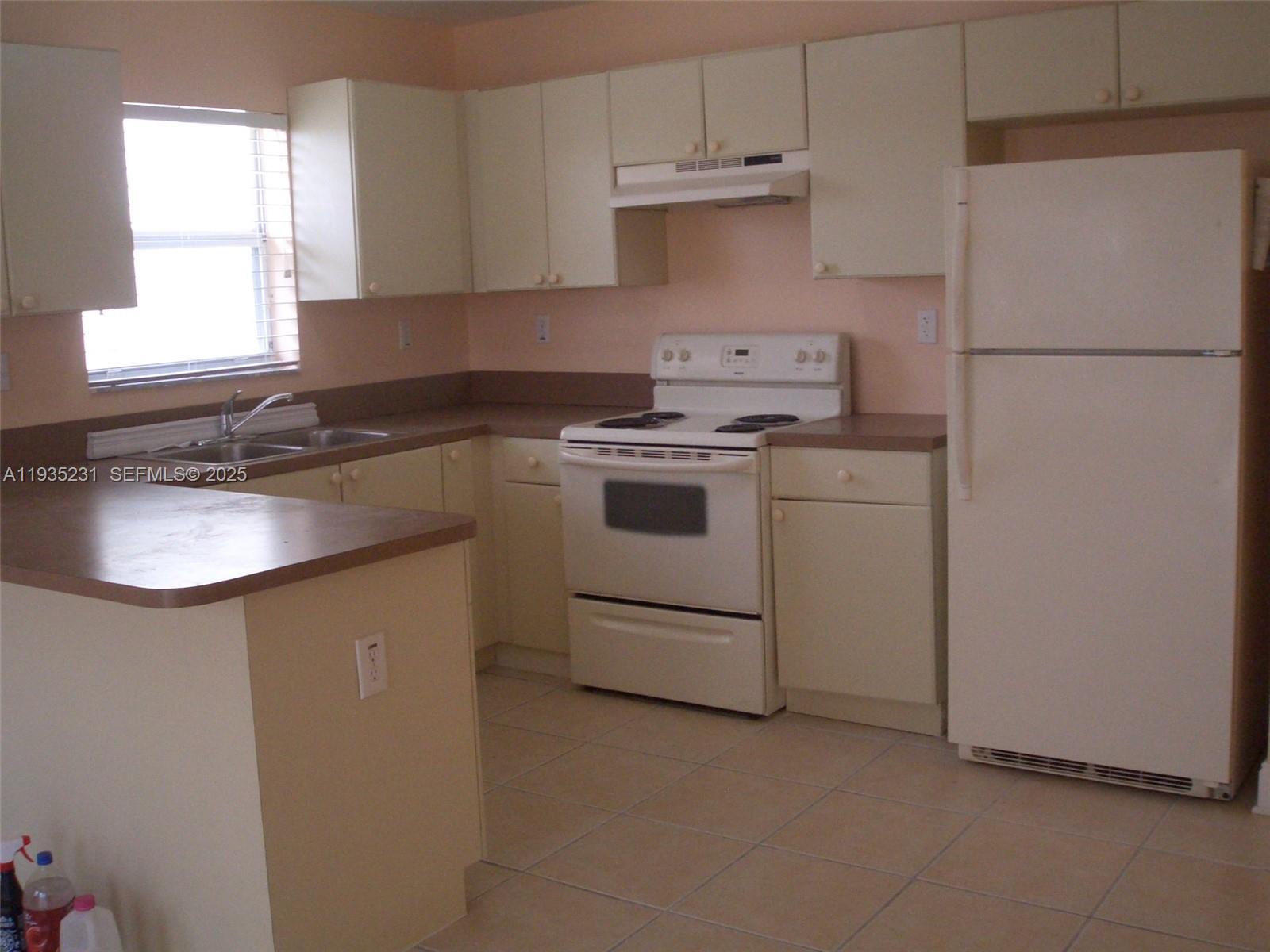 25863 Southwest 128th Court Homestead, FL 33032 - Photo 1 of 1 a kitchen with a stove sink and refrigerator