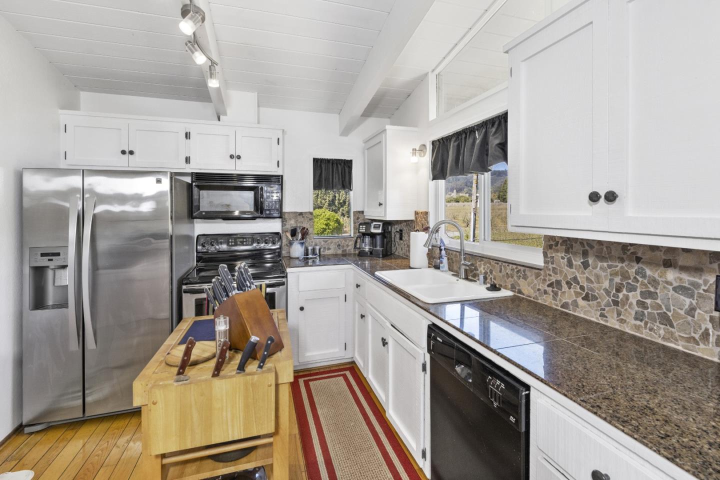757 Pleasant Valley Road Aptos, CA 95003 - Photo 19 of 41 a kitchen with stainless steel appliances kitchen island granite countertop a sink stove and refrigerator