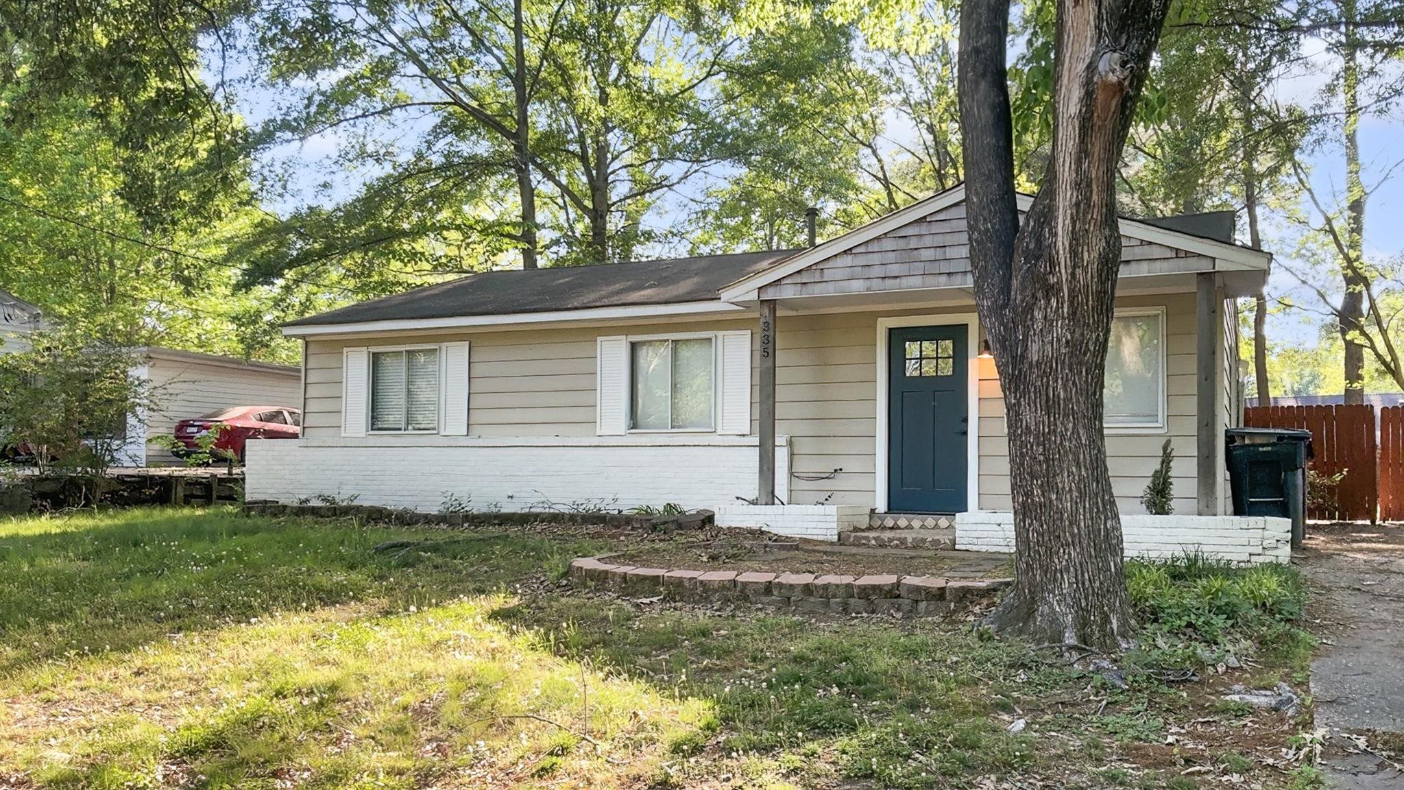 335 Homeville Road Collierville, TN 38017 - Photo 8 of 11 Single-story residence featuring light-colored siding, a dark teal entry door with glass panes, and white window shutters