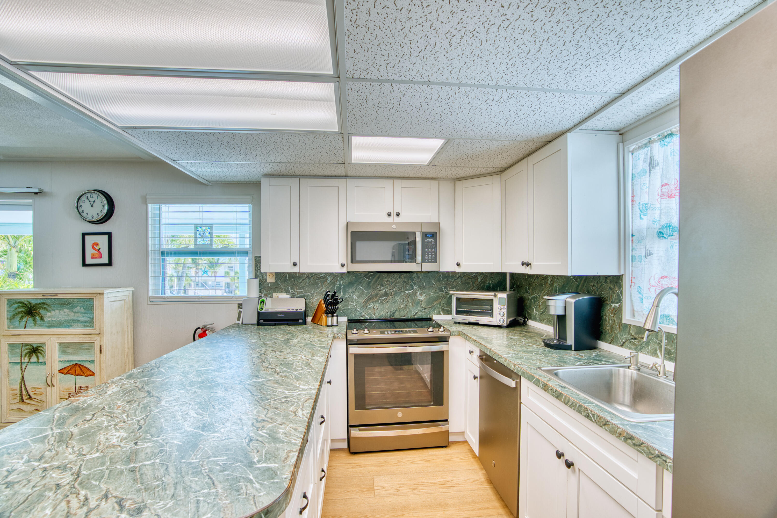 330-340 4th Street Key Colony Beach, FL 33051 - Photo 22 of 68 a kitchen with stainless steel appliances granite countertop a stove sink and cabinets