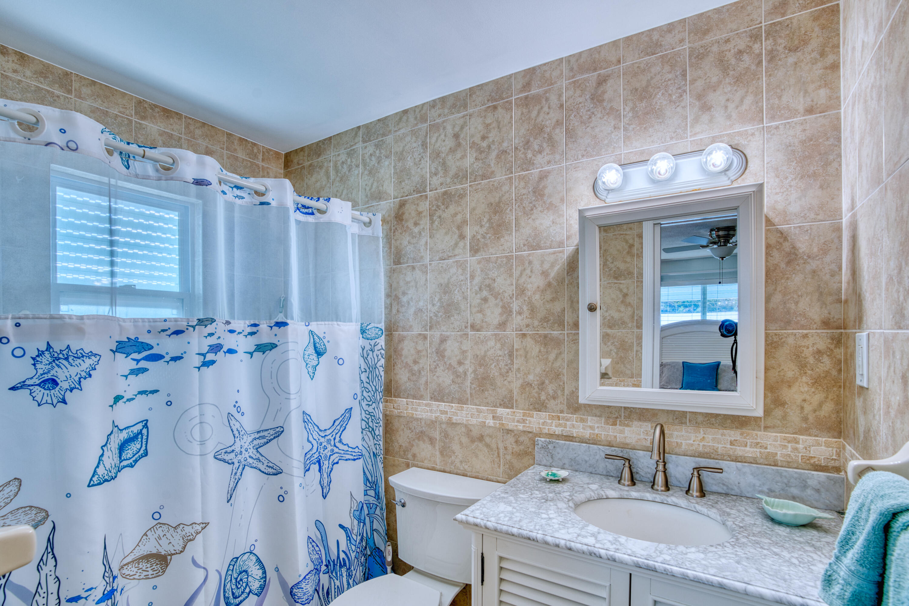 330-340 4th Street Key Colony Beach, FL 33051 - Photo 28 of 68 a bathroom with a granite countertop sink a toilet and shower curtain