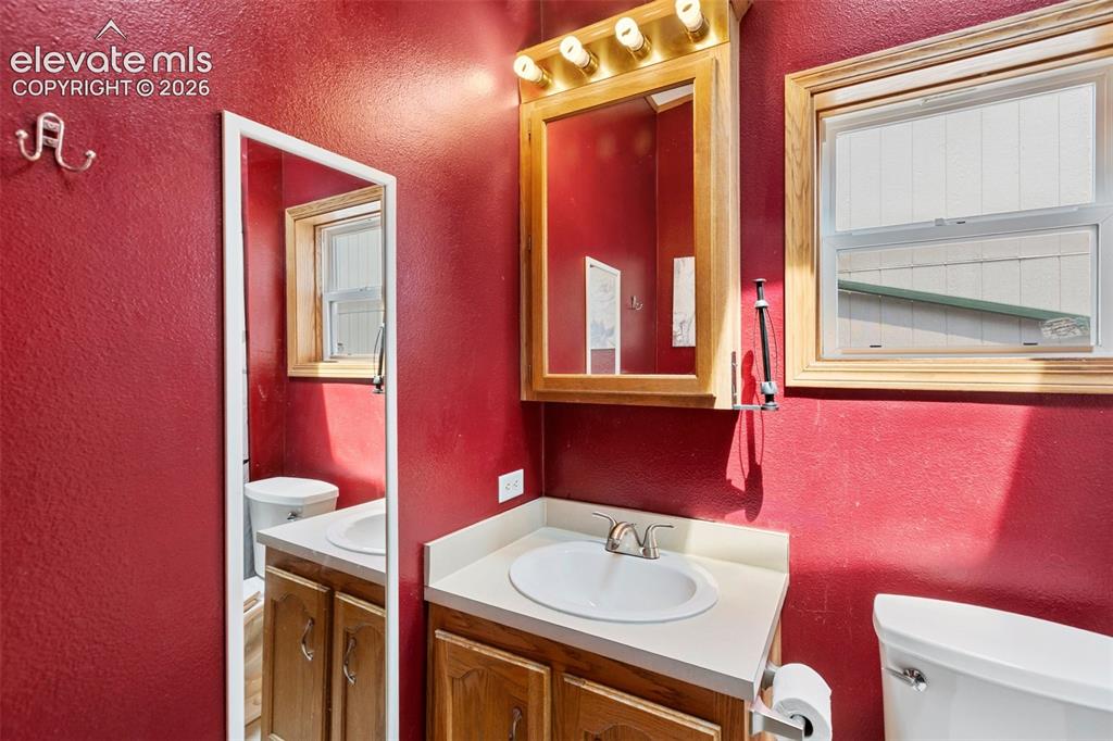 1350 South Calhan Highway Yoder, CO 80864 - Photo 34 of 45 Bathroom featuring a wood-finish vanity with a white oval sink and chrome faucet