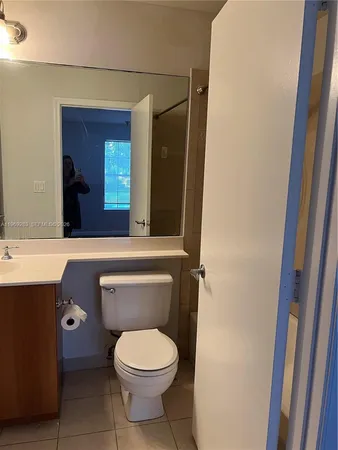 a bathroom with a toilet a sink and mirror