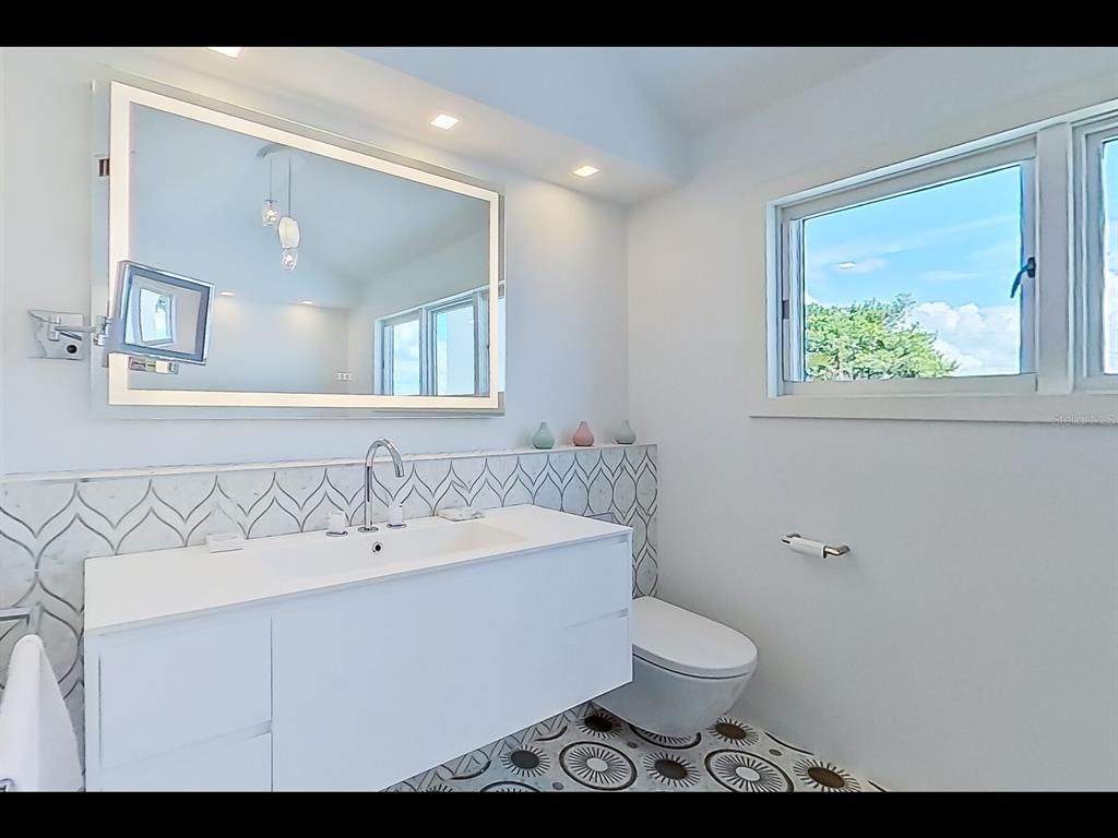 2021 20th Street West Boca Grande, FL 33921 - Photo 19 of 66 a bathroom with a toilet sink and mirror