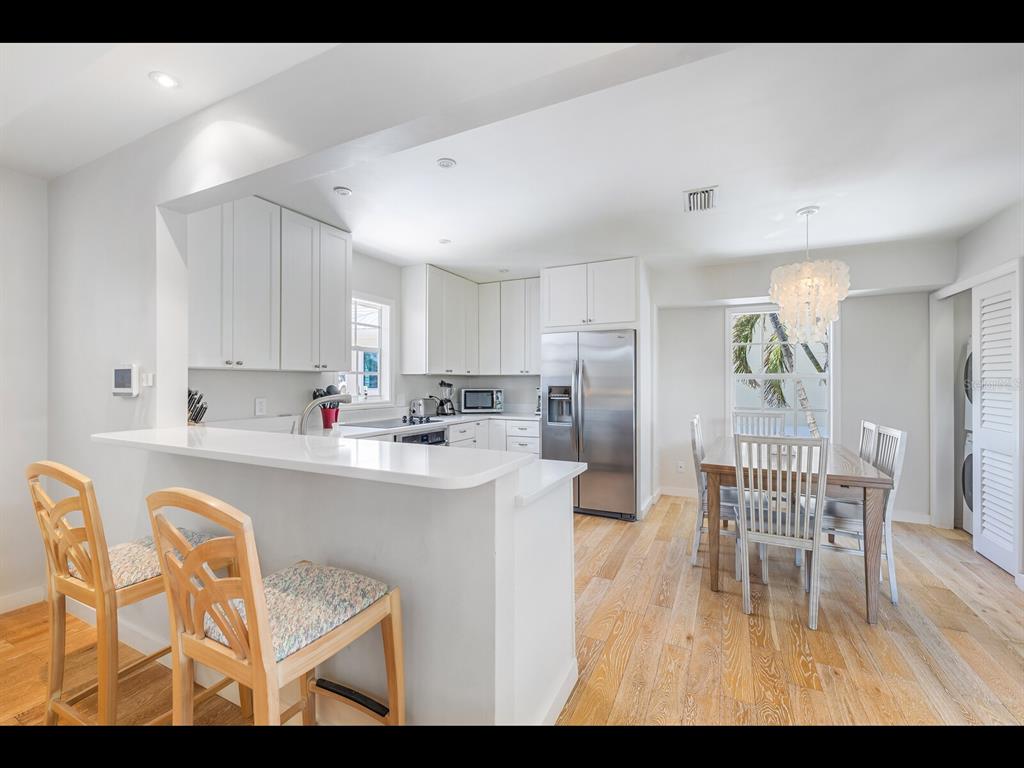 2021 20th Street West Boca Grande, FL 33921 - Photo 42 of 66 a kitchen with a dining table chairs and white cabinets