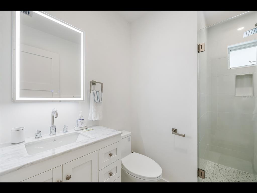2021 20th Street West Boca Grande, FL 33921 - Photo 53 of 66 a bathroom with a sink a toilet and mirror