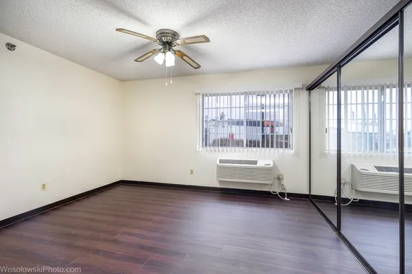 an empty room with wooden floor and windows
