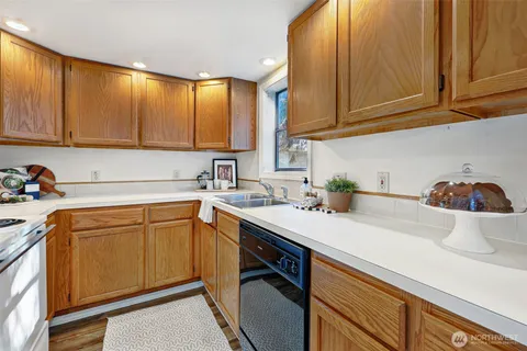 a kitchen with stainless steel appliances granite countertop a sink a stove and cabinets