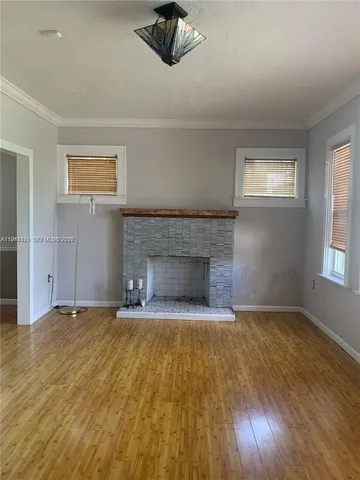 a view of empty room with wooden floor and fireplace
