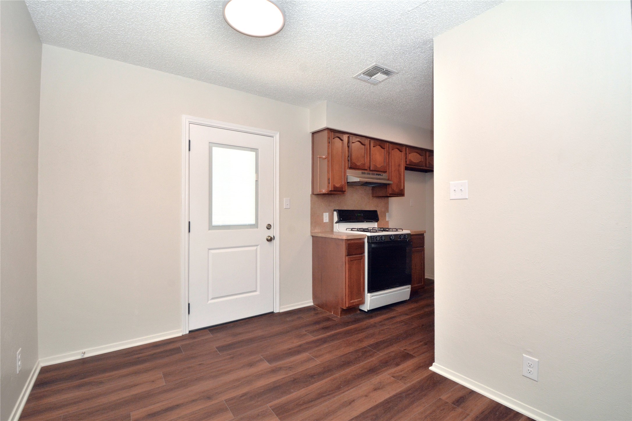 11314 Walnut Ridge Drive, Unit B Austin, TX 78753 - Photo 5 of 19 Rich wood plank flooring flows through this bright kitchen, complete with a functional range and ample cabinetry.