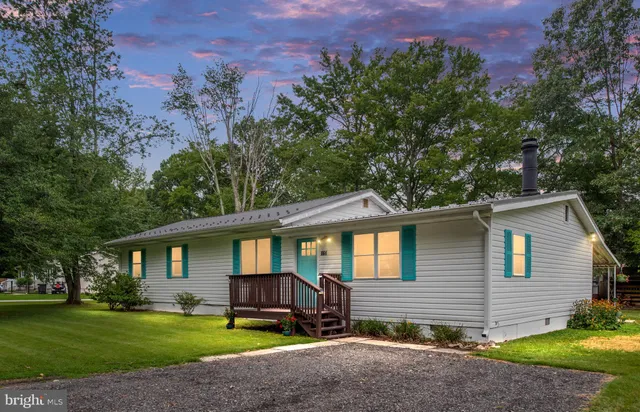 a front view of a house with a yard and trees