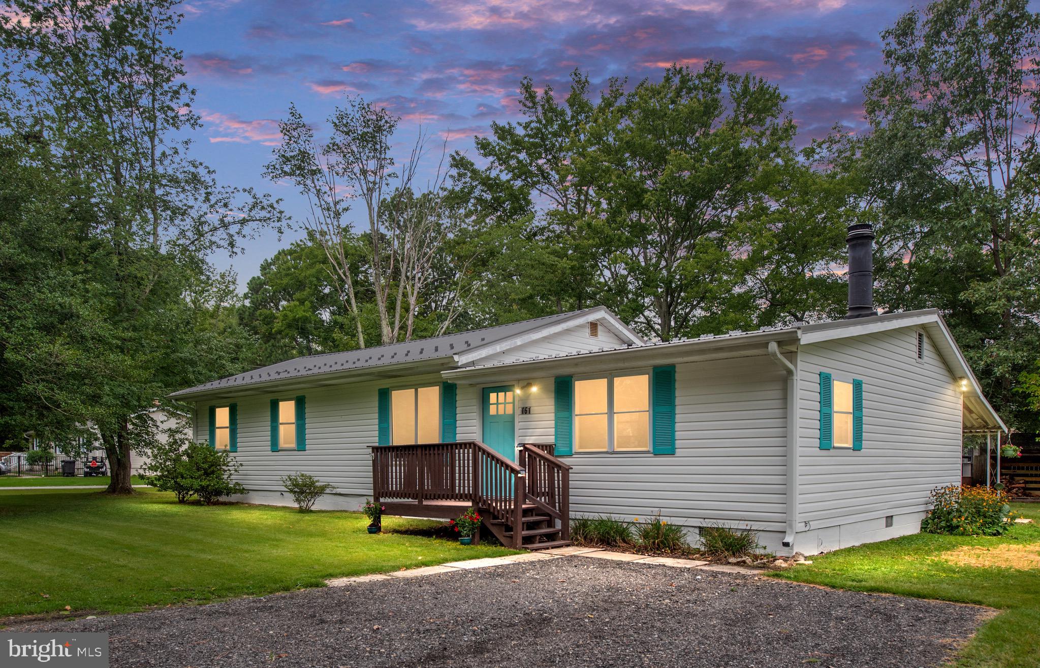 a front view of a house with a yard and trees