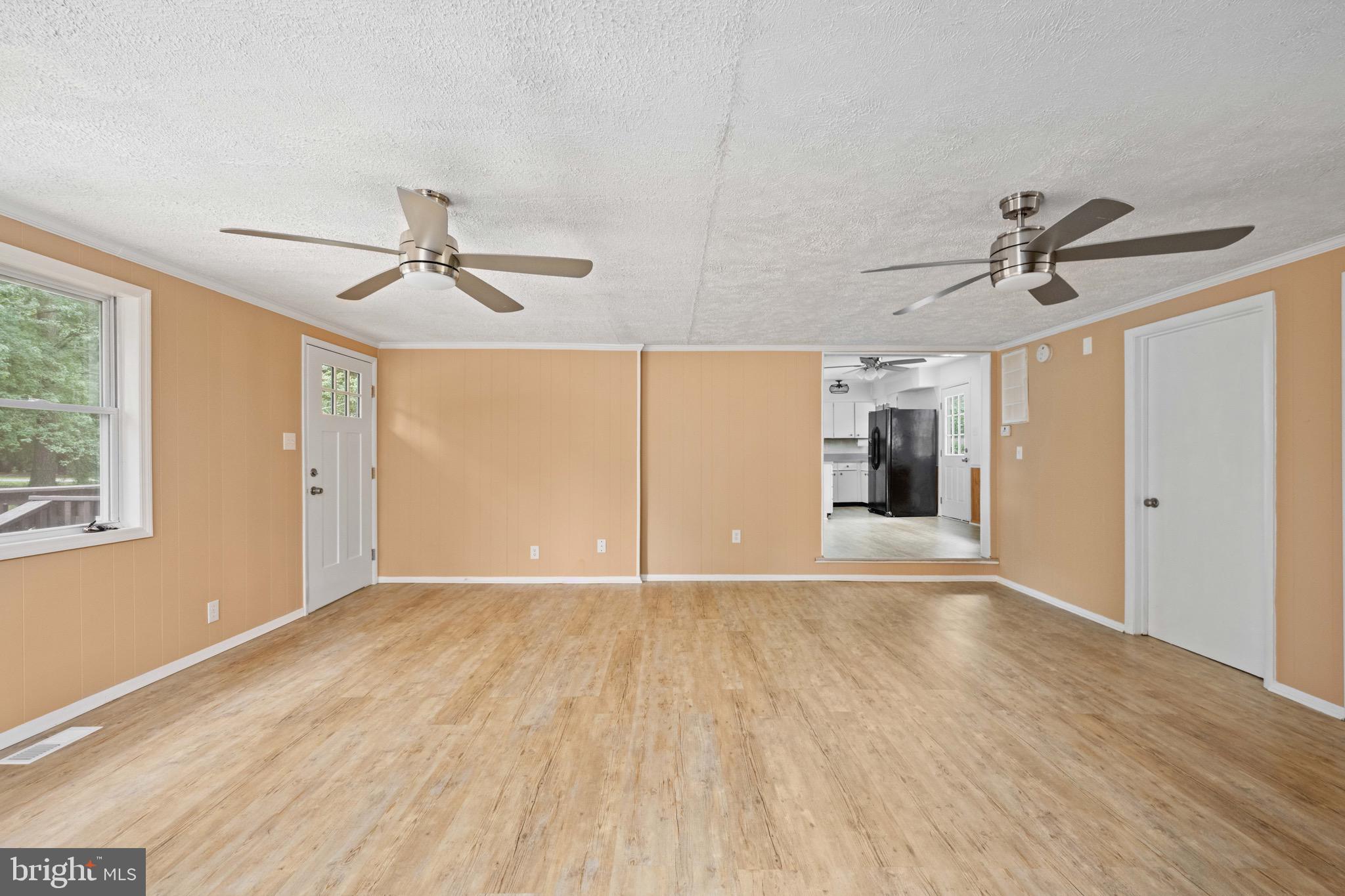 161 8th Street Colonial Beach, VA 22443 - Photo 10 of 71 a view of empty room with wooden floor and fan