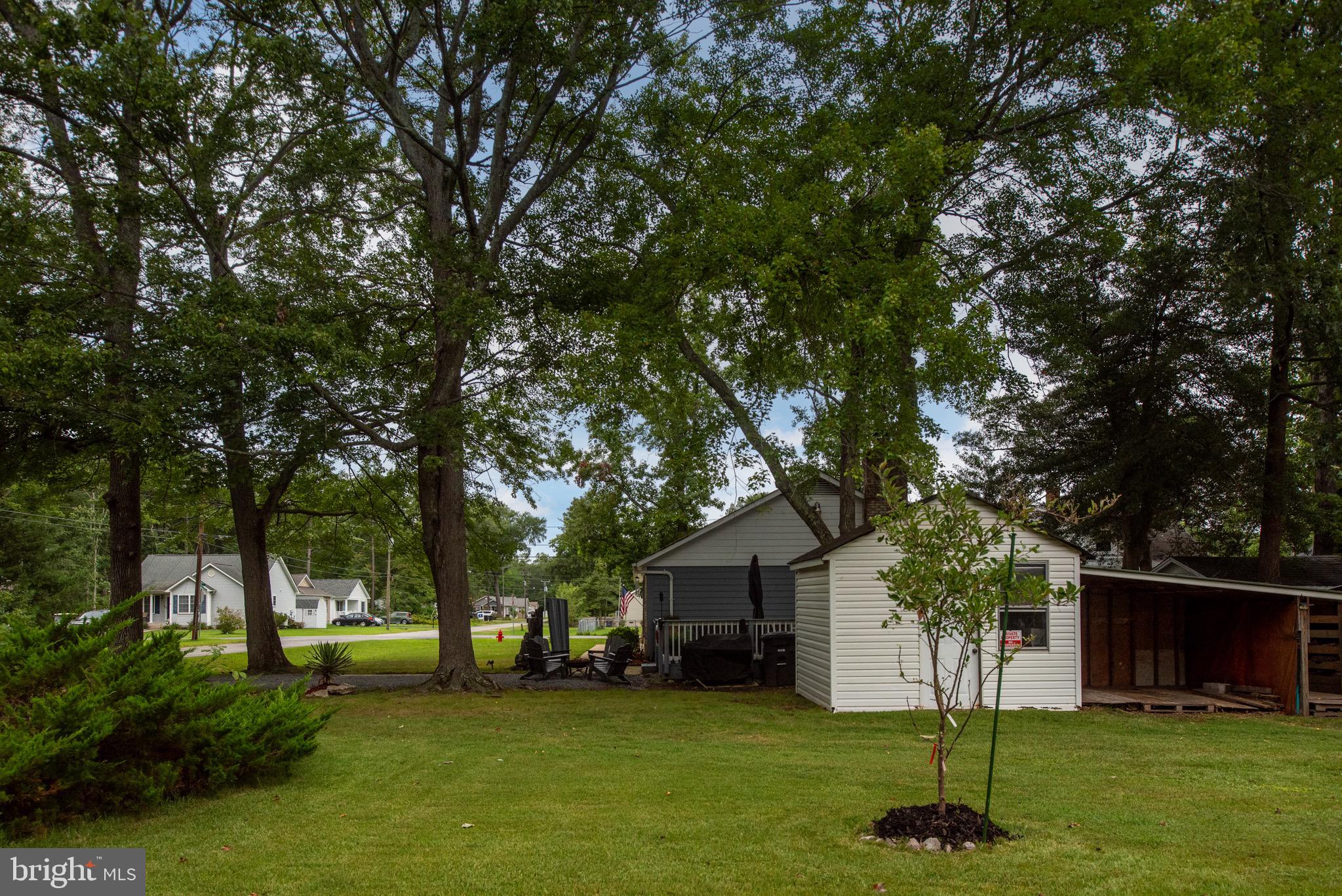 161 8th Street Colonial Beach, VA 22443 - Photo 52 of 71 a front view of a house with a garden and trees