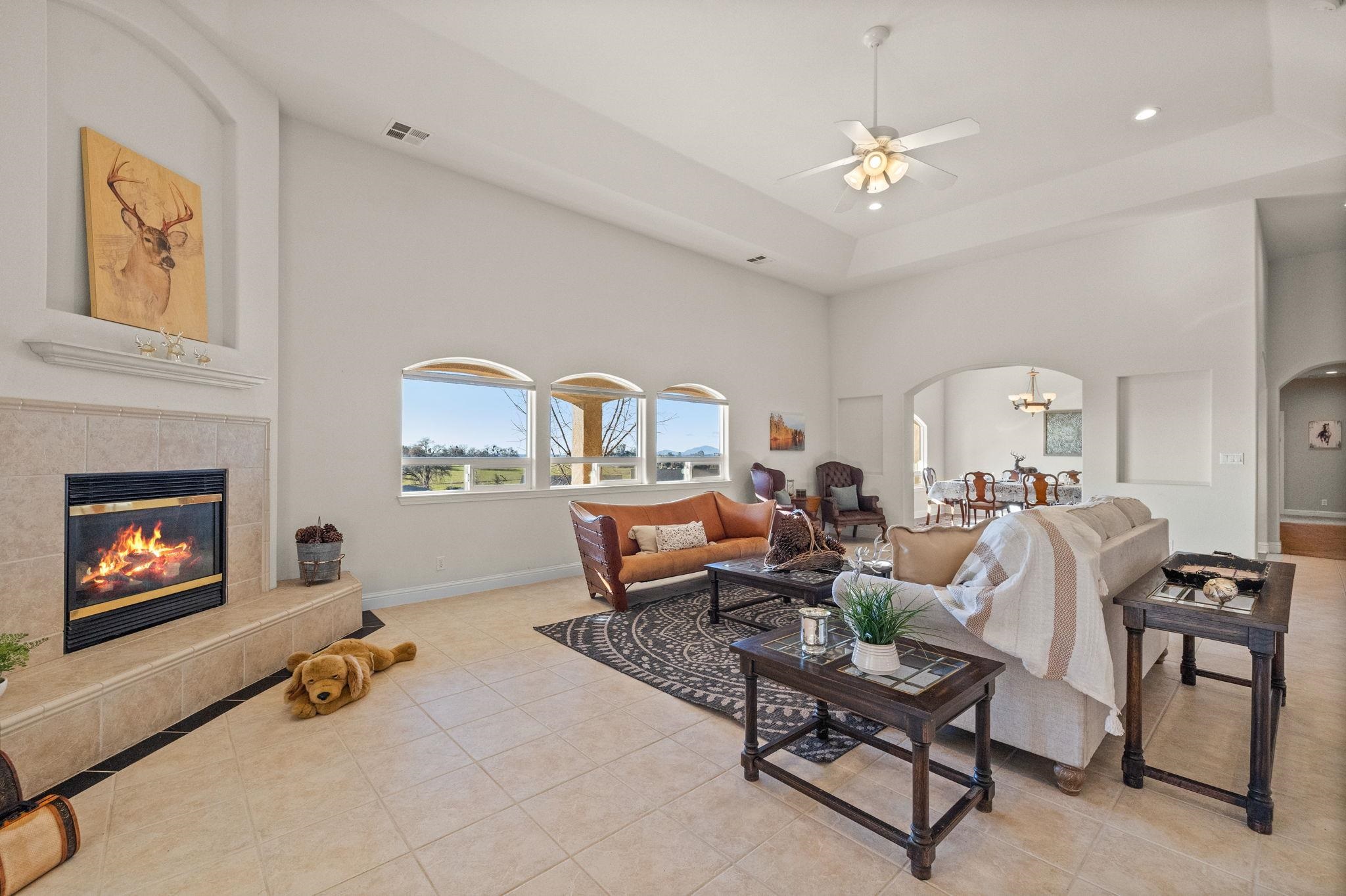 17550 Old Wards Ferry Road Sonora, CA 95370 - Photo 11 of 59 Living room featuring a high ceiling, arched walkways, light tile patterned flooring, a tile fireplace, and recessed lighting