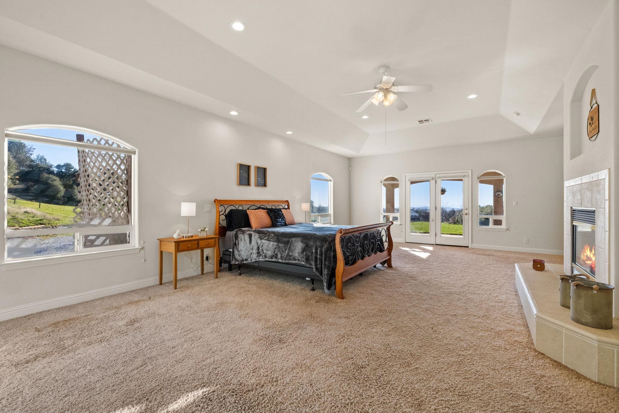 17550 Old Wards Ferry Road Sonora, CA 95370 - Photo 21 of 59 Bedroom with carpet flooring, a tile fireplace, access to exterior, a ceiling fan, and recessed lighting