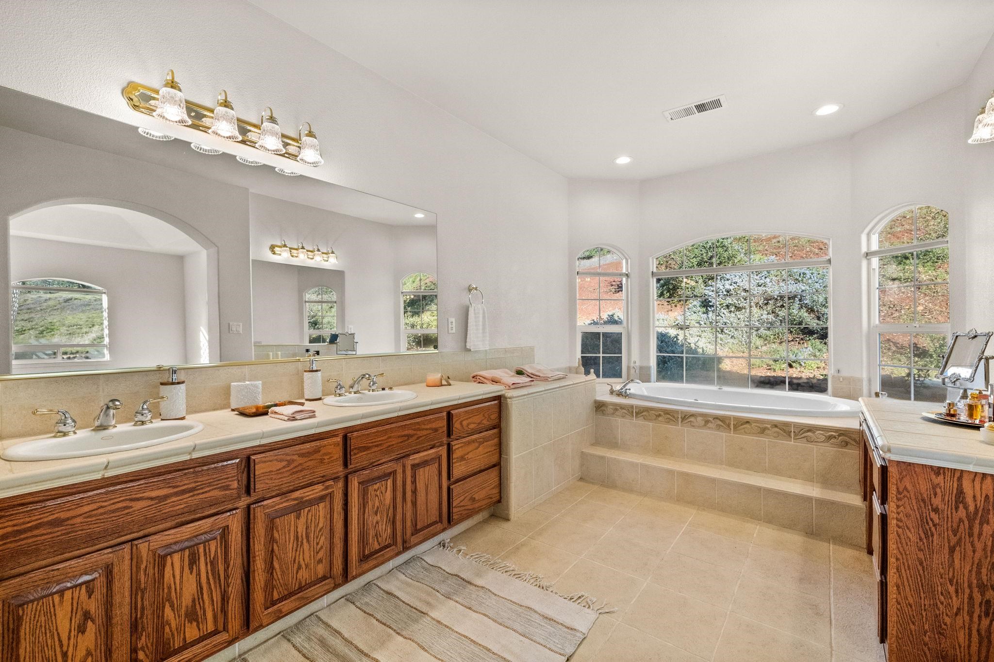 17550 Old Wards Ferry Road Sonora, CA 95370 - Photo 23 of 59 Bathroom featuring double vanity, a bath, light tile patterned flooring, plenty of natural light, and recessed lighting