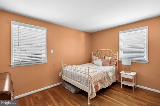 a bedroom with a bed wooden floor and window