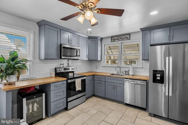 a kitchen with stainless steel appliances granite countertop a refrigerator a stove a sink a microwave and island