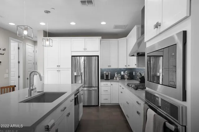 a kitchen with stainless steel appliances a sink stove and refrigerator