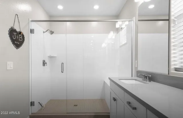 a bathroom with a shower sink and mirror